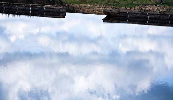 "reflected sky in still water of reservoir"