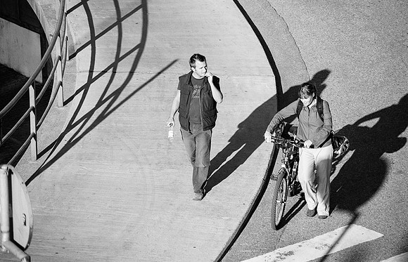 "Man and woman with bicycle, walking and in conversation"