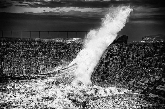 Surging wave overtops harbour wall